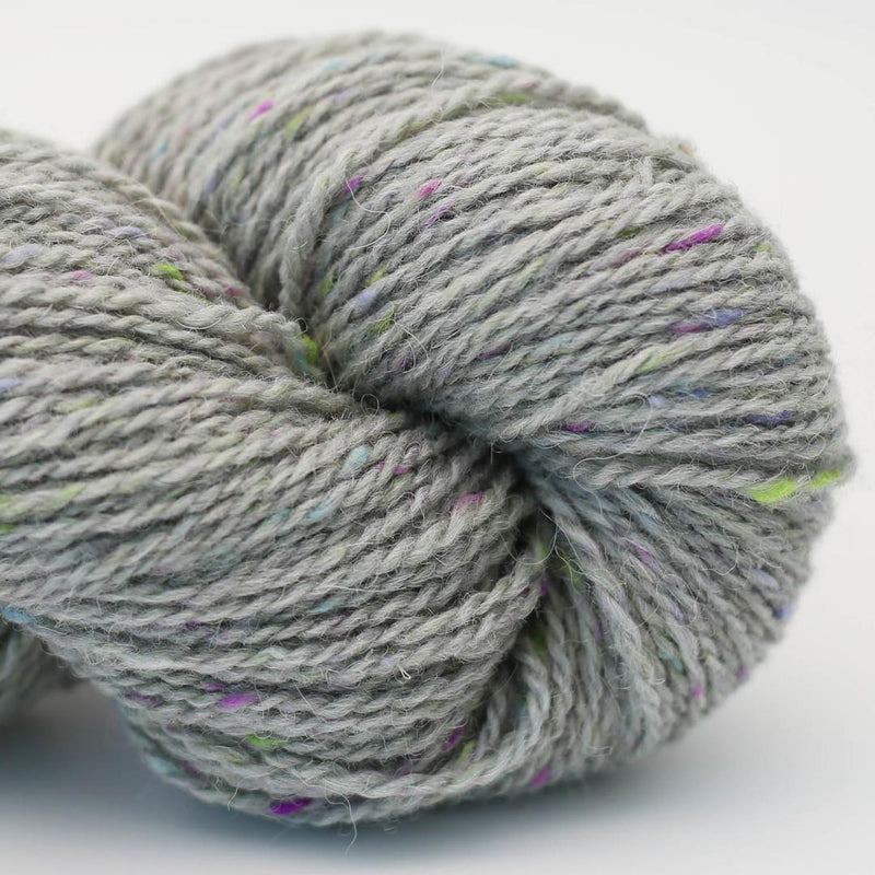 Close-up of a skein of gray yarn with colourful speckles Beara Irish wool and UK alpaca tweed dk, worsted or aran weight yarn by Hey Mama Wolf 