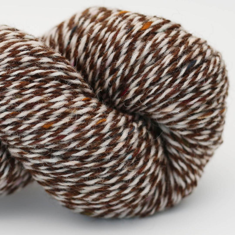 Close-up of a skein of brown and white marled yarn Beara Irish wool and UK alpaca tweed dk, worsted or aran weight yarn by Hey Mama Wolf 